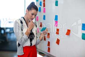 Woman reading notes in office