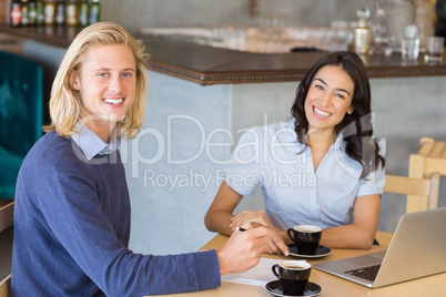 Business colleagues smiling while having a cup of tea