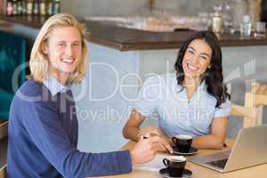 Business colleagues smiling while having a cup of tea