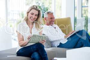 Smiling mature couple using technology