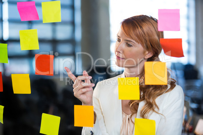 Businesswoman pointing at sticky notes