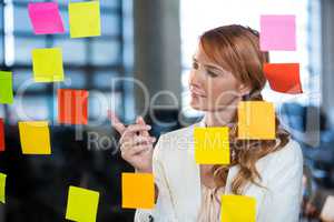 Businesswoman pointing at sticky notes