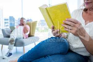 Cropped image of woman reading book with man at home