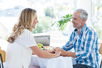 Mature couple holding hands in restaurant