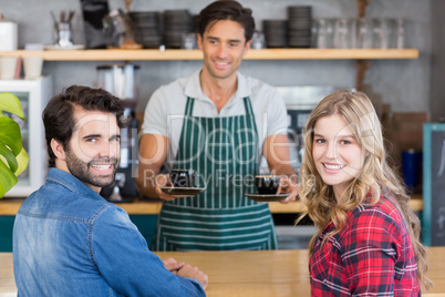 Waiter offering coffee to a couple