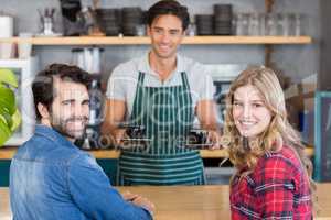 Waiter offering coffee to a couple