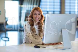 Portrait of smiling woman using computer