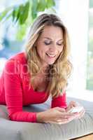 Woman using cellphone while relaxing on seat