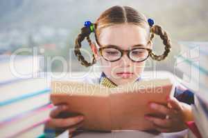 Close-up of schoolkid reading book in classroom