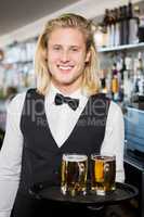 Portrait of waiter holding tray with beer mug