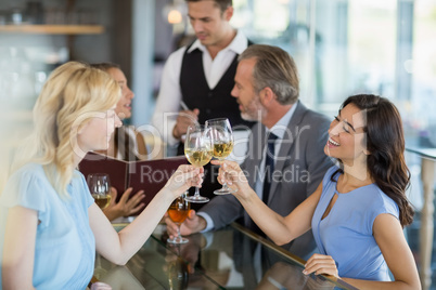 Waiter taking the order while colleagues toasting glasses of win
