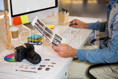 Photo editor working at computer desk