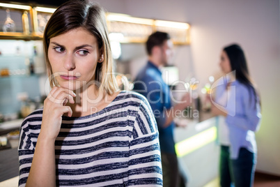 Upset woman while boyfriend talking with female friend