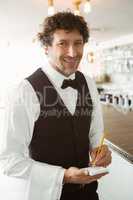 Portrait of waiter holding notepad and pen