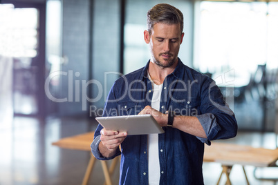 Man checking time while holding tablet