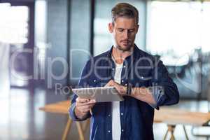 Man checking time while holding tablet