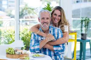 Happy woman embracing husband in restaurant