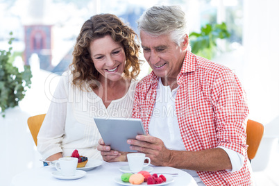 Couple looking in tablet computer at restaurant