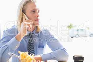 Man talking on mobile phone while having breakfast