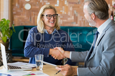 Business colleagues shaking hands in meeting