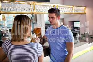 Couple drinking beer by counter