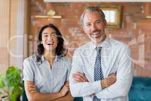 Happy man and woman standing with arms crossed