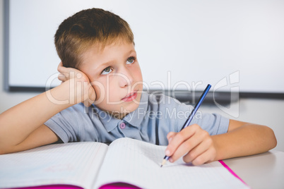 Schoolboy doing homework in classroom