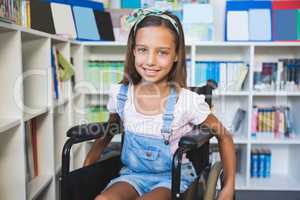 Disabled smiling schoolgirl in library