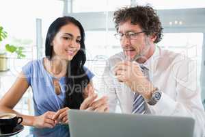 Businessman discussing with colleague over laptop