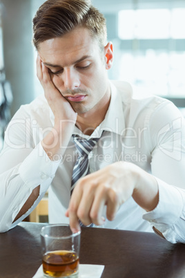 Depressed man looking at alcohol glass
