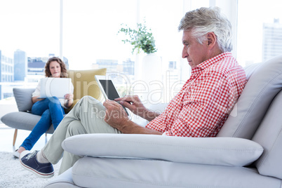 Mature man using tablet computer while sitting