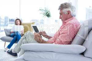 Mature man using tablet computer while sitting