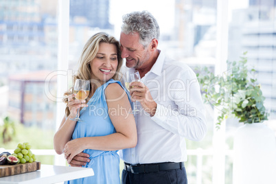 Romantic mature couple holding white wine at restaurant