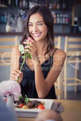 Beautiful woman holding rose flower and smiling