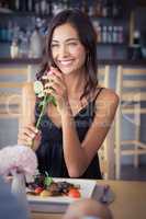 Beautiful woman holding rose flower and smiling