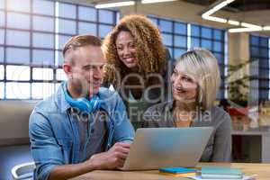 Business people discussing over laptop