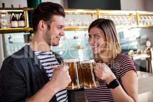 Happy young couple toasting beer mug