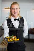 Waiter holding a plate of food in restaurant
