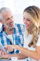 Woman pointing on digital tablet while sitting by husband