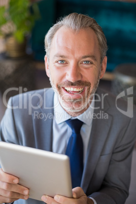 Businessman using digital tablet in cafÃ©