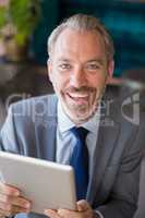 Businessman using digital tablet in cafÃ©