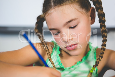 Schoolgirl doing homework in classroom