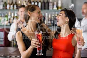 Two beautiful women holding cocktail glass