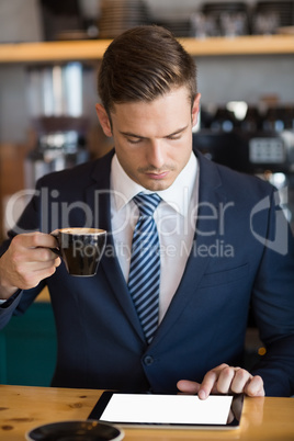 Close-up of businessman using digital tablet in cafÃ©