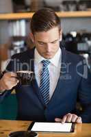 Close-up of businessman using digital tablet in cafÃ©