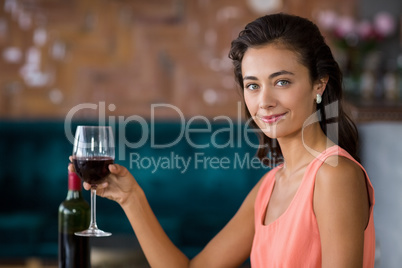 Smiling woman holding glass of red wine