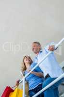 Couple holding shopping bags by railing