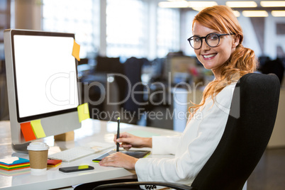 Pretty businesswoman using graphics tablet