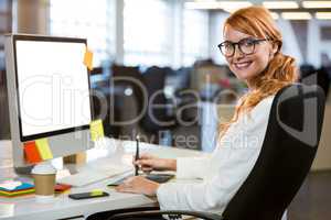Pretty businesswoman using graphics tablet