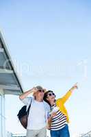 Woman with man pointing against clear sky